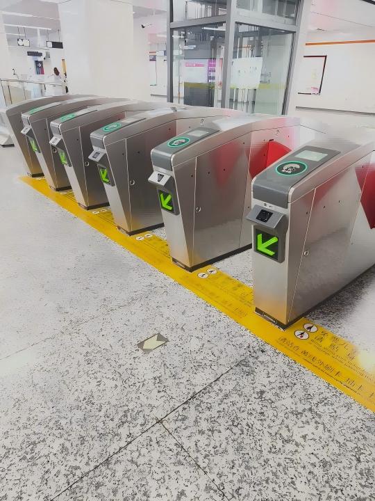Metro station entry gates with green arrows and a security checkpoint visible